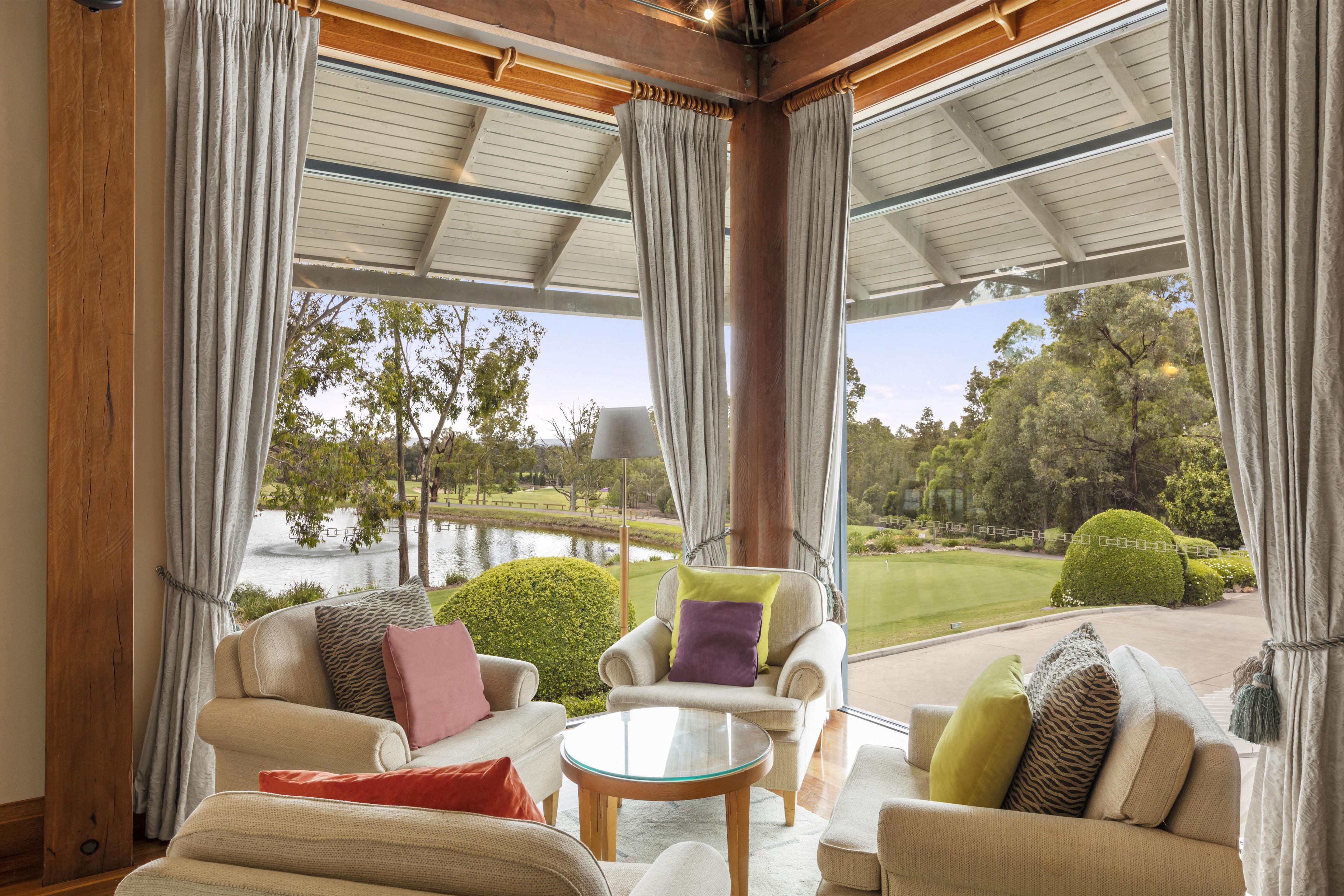 A cozy seating area with a view of a lake and park.