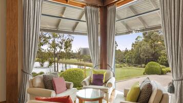 A cozy seating area with a view of a lake and park.