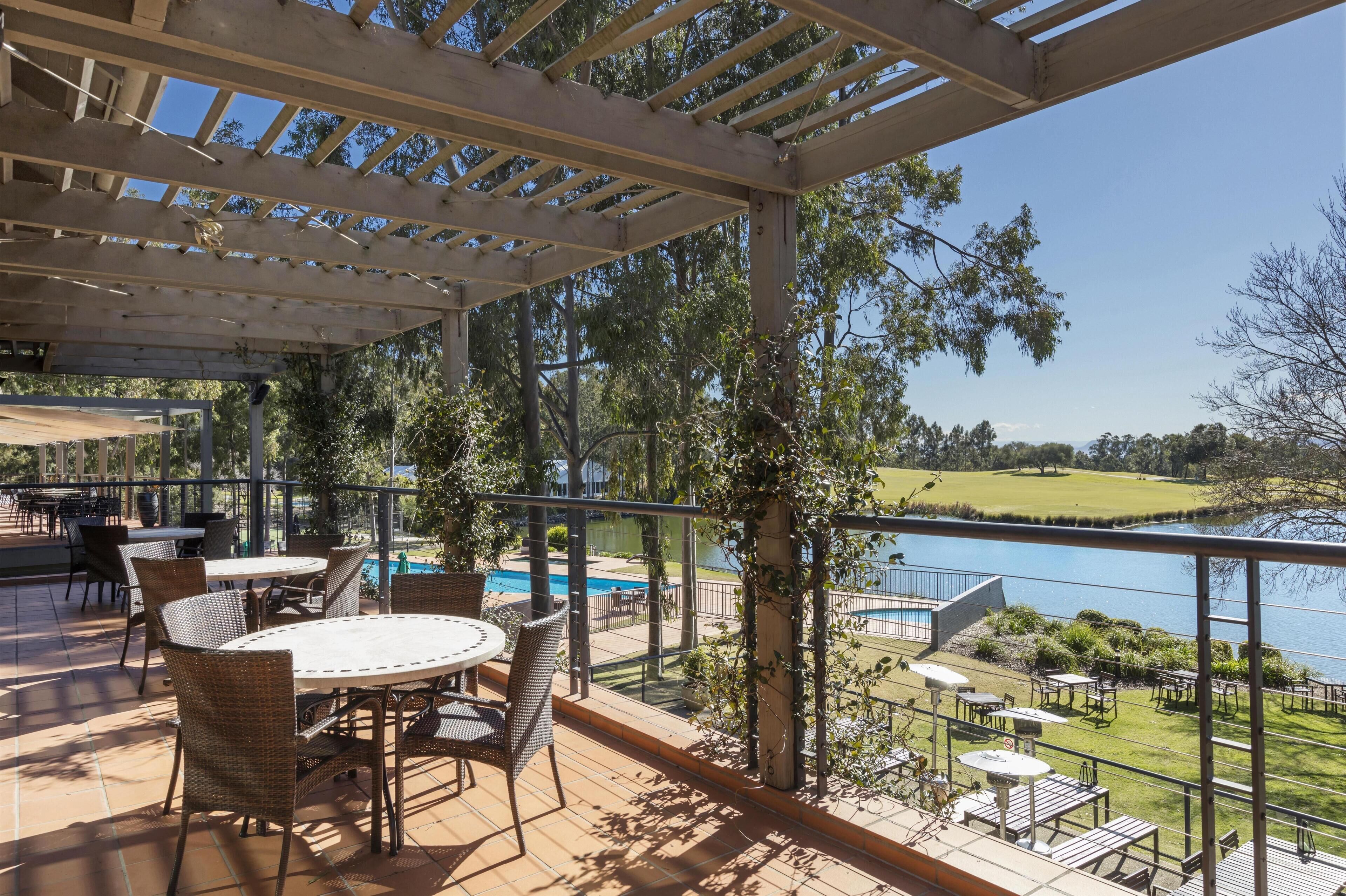 Uma área de terraço ao ar livre com piscina, mesas e cadeiras de jantar.