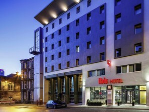 Een hotel met een moderne gevel, grote ramen en een opvallende ingang.