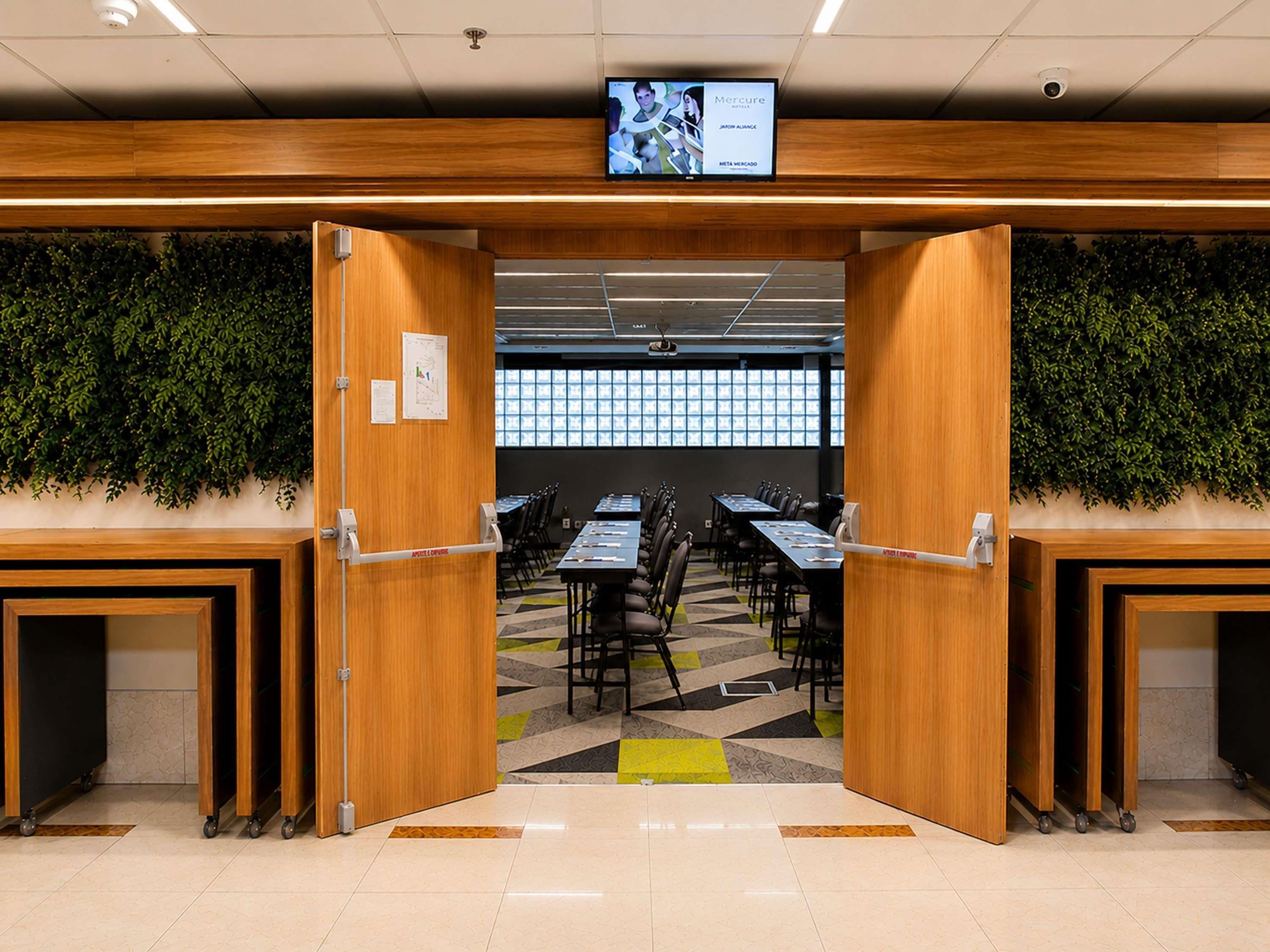 A conference room with tables, chairs, and a television screen displaying an advertisement.