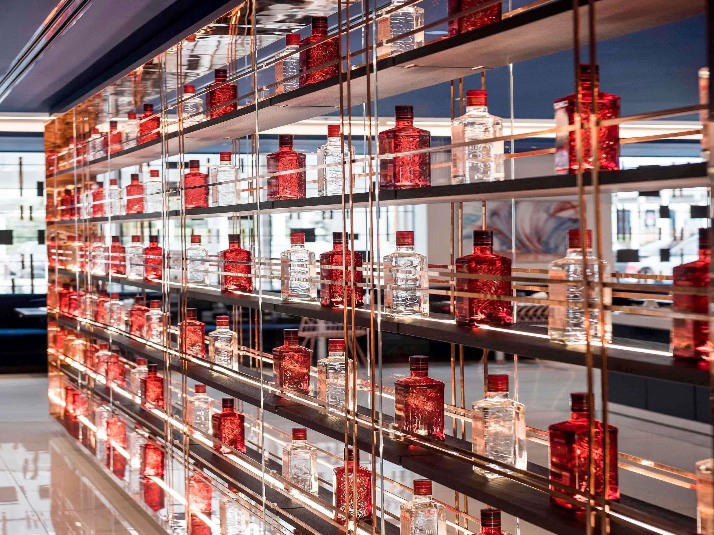 A wall of shelves with various bottles, likely containing beverages.