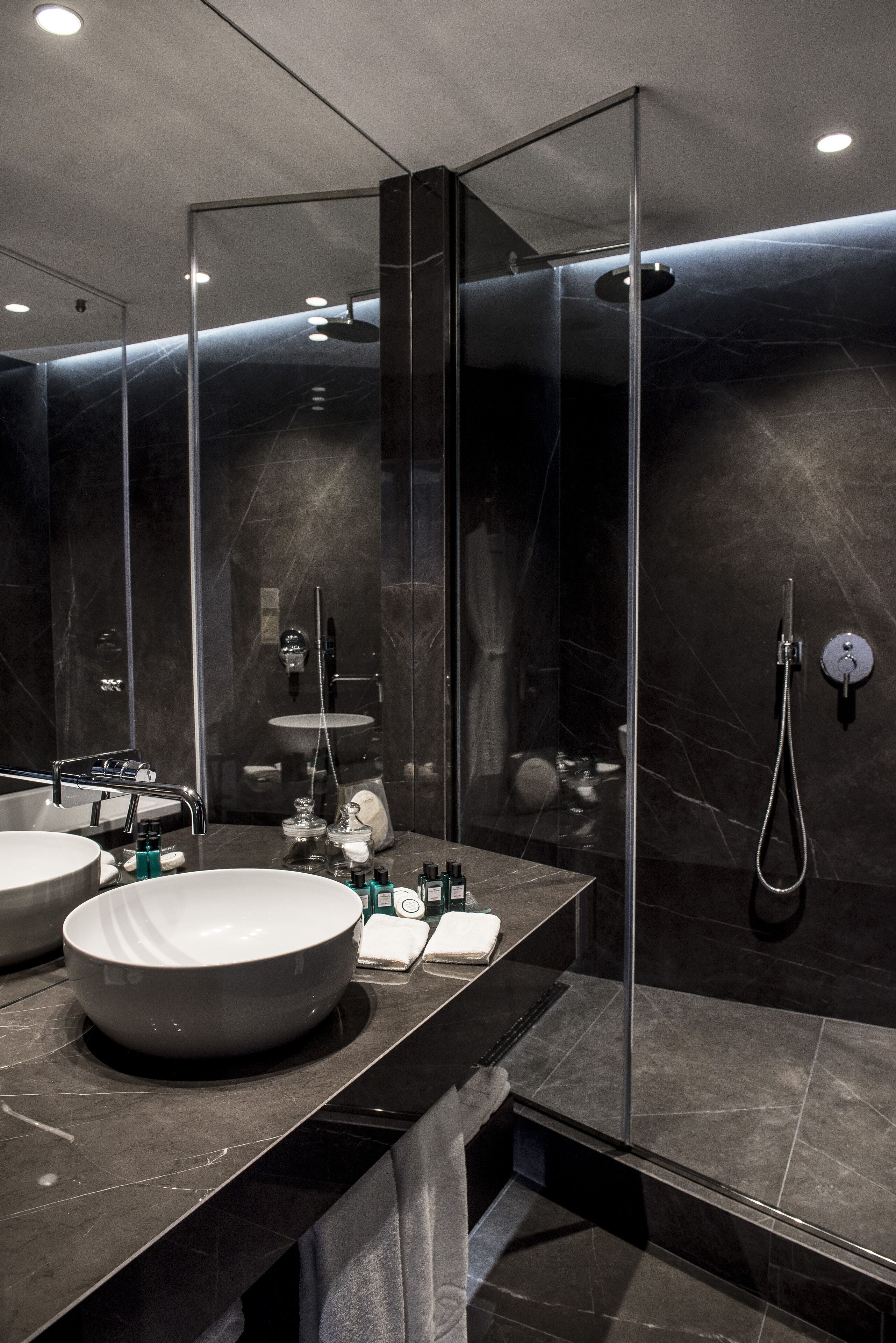 Un bagno moderno con un grande specchio, due lavabi e una doccia.