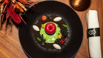 Um prato preto com uma sobremesa sobre uma mesa de madeira.
