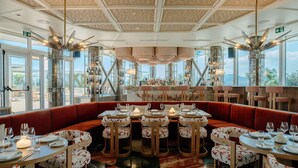 A restaurant with a bar area, booths, and a view of the outdoors.