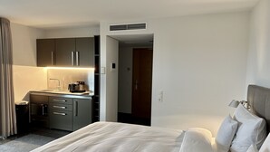 Una habitación de hotel con cama, kitchenette y baño.