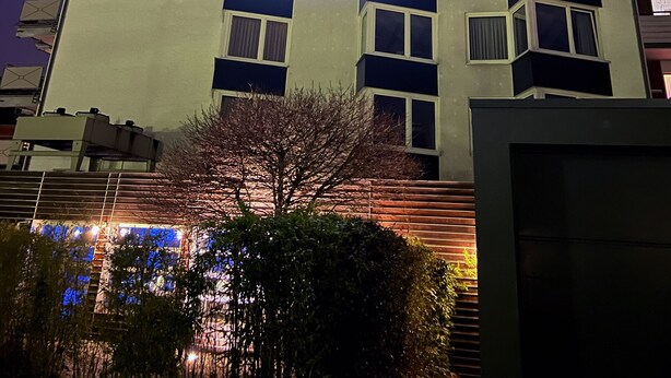 Un edificio con un cartel que dice 'AVIDONAPARTMENTS' de noche.