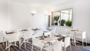 A modern hotel room with white furniture, a large window with a view of greenery, and a clean, minimalist design. - Hotel Abrial by Soniho (Cannes)