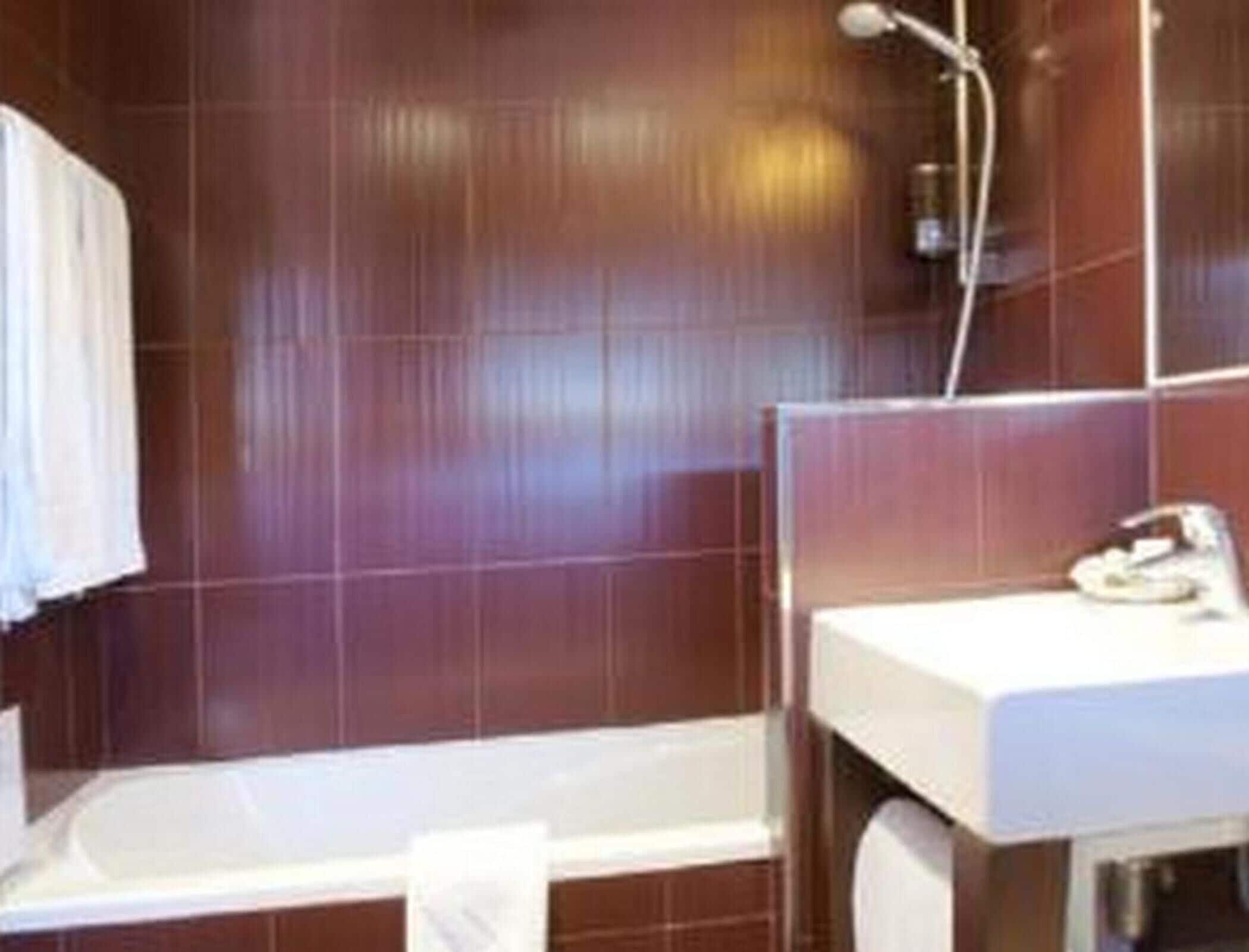 A bathroom with a bathtub, a sink, and a shower.