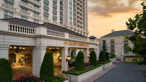 Un hôtel doté d’une entrée imposante, de nombreux balcons et de jardins bien entretenus.