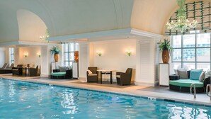 Une piscine intérieure dotée d’espaces de détente, de sièges et d’un lustre.