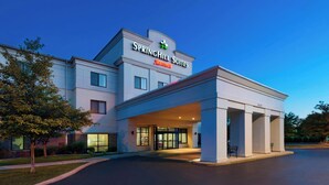 Ein SpringHill Suites Hotel mit moderner Außenansicht, großem Glas Eingangsbereich und einem gut beleuchteten Zufahrtsweg.