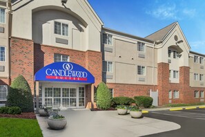Welcome to Candlewood Suites, featuring a modern exterior with a brick and stucco design, accessible entrance and ample parking.