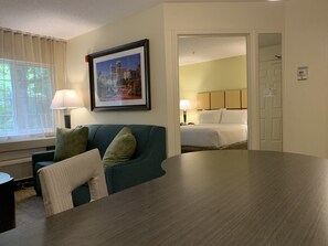 A hotel room with a bed, a desk, a chair, and a window with curtains. - Candlewood Suites Raleigh Crabtree by IHG (Raleigh)