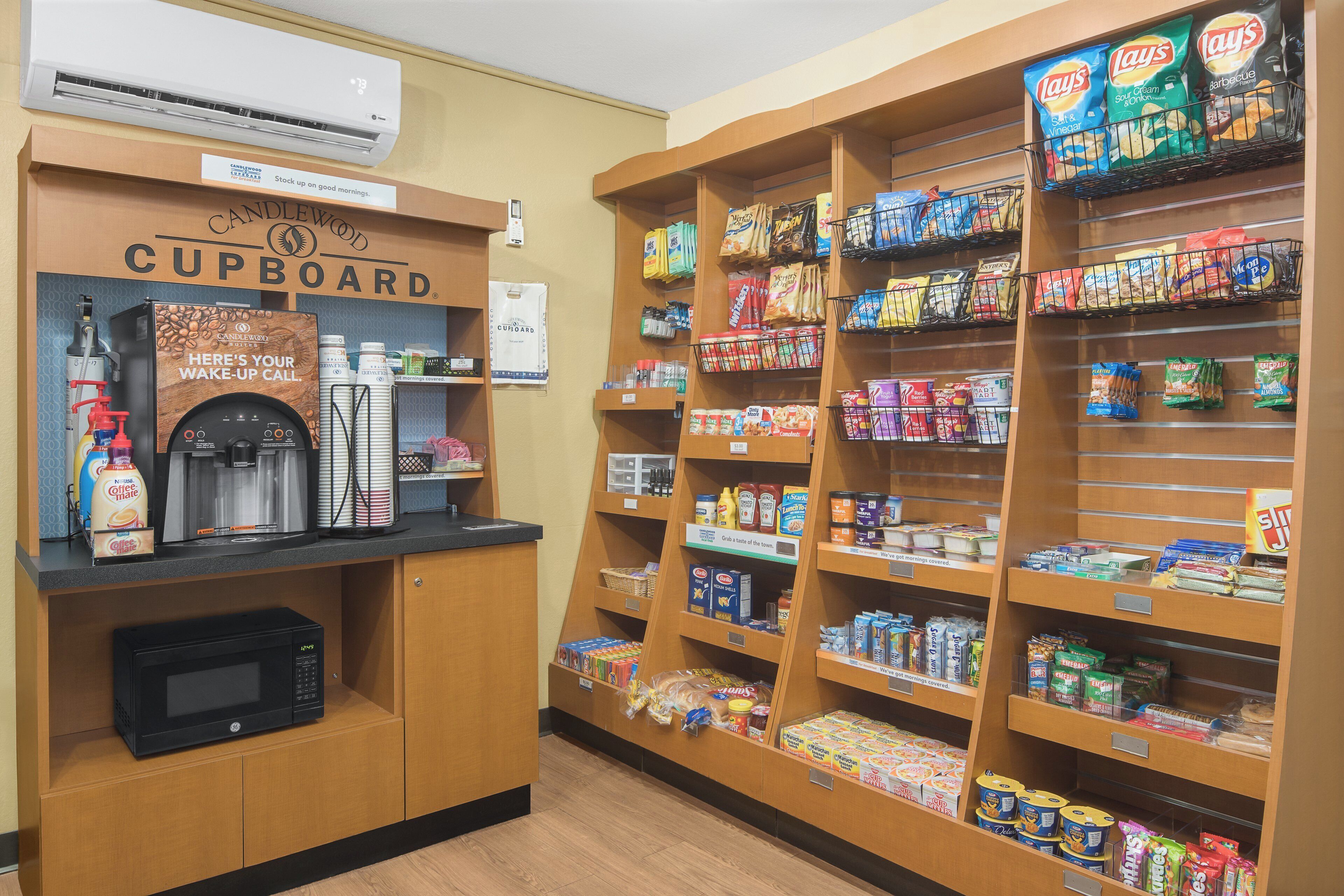 A kitchenette area with a coffee machine, a microwave, and a sign that reads 'Cupboard.'