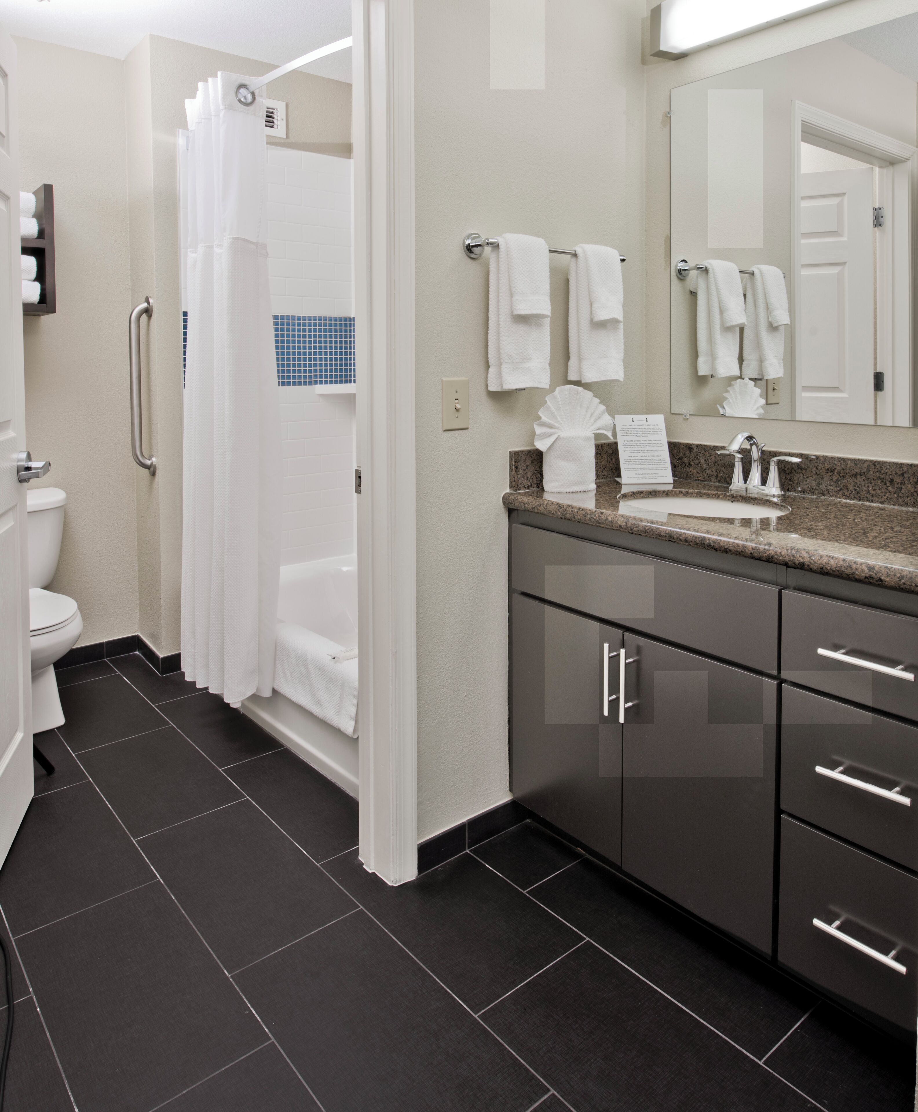 A modern bathroom with a shower, toilet, and sink.
