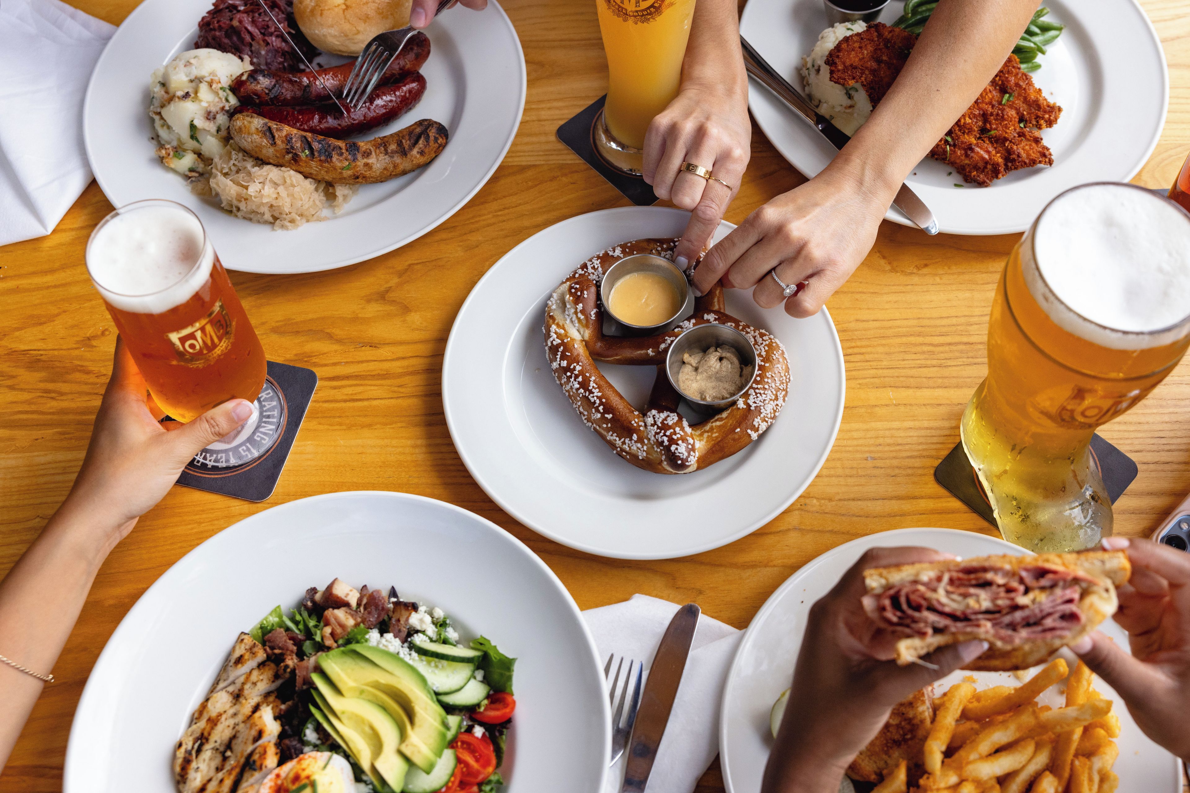 Une table à manger avec différents plats, boissons et ustensiles.