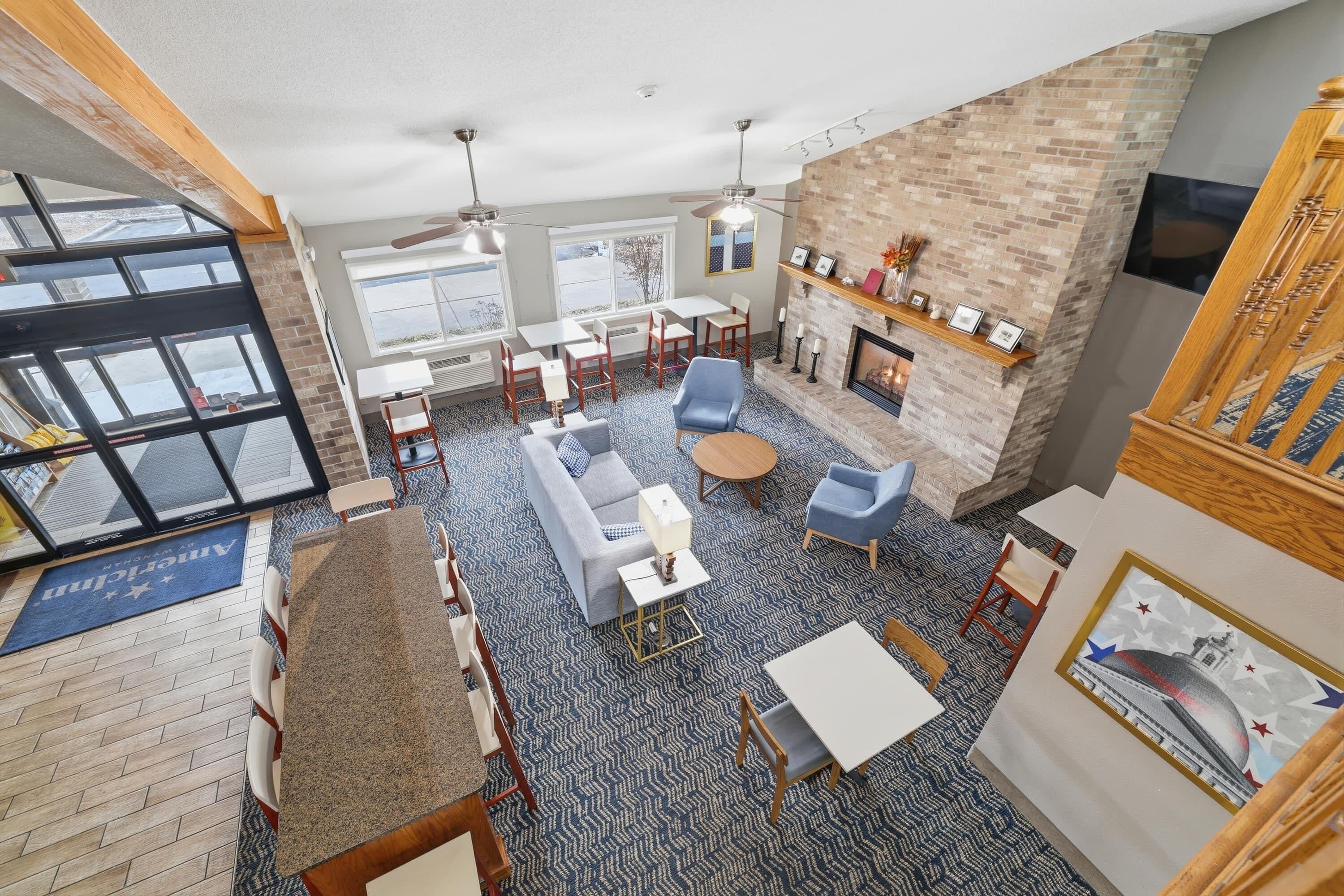 A spacious room with a fireplace, seating area, and a dining table.