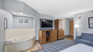 Une salle de bain moderne avec une baignoire, un meuble en bois et un téléviseur à écran plat.
