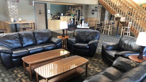 A hotel lobby with leather sofas, a wooden coffee table, and a reception desk. - Cobblestone Hotel & Suites – Wisconsin Rapids (Wisconsin Rapids)