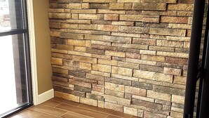 A room with a brick wall and wooden flooring.
