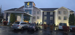 A Comfort Inn hotel with a covered entrance, multiple parking spaces, and a modern architectural design.