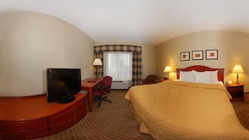 A hotel room with a bed, a desk with a TV, a chair, a window with curtains, and two bedside lamps.