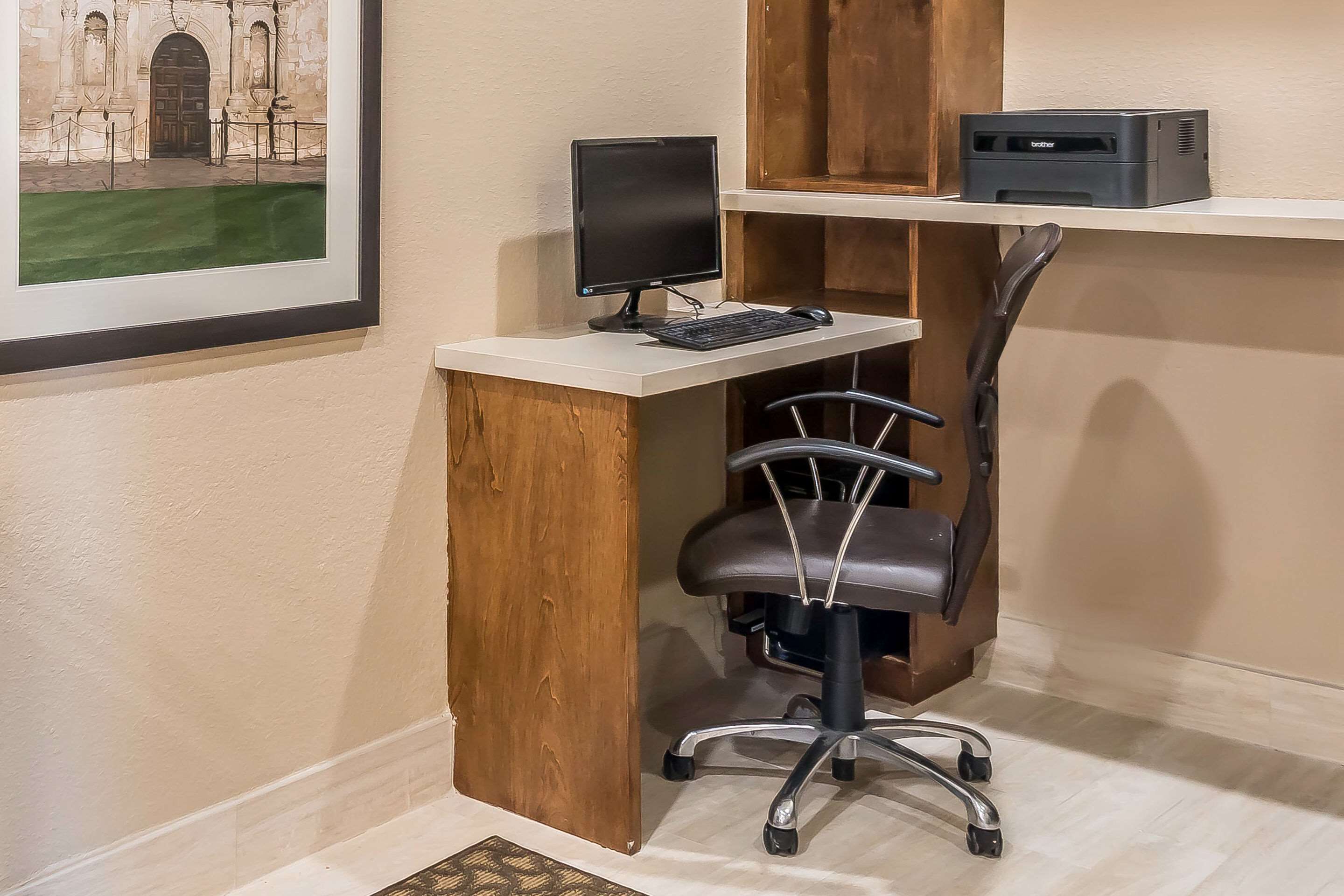 A small office space with a desk, computer, chair, and printer.