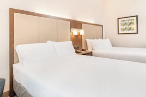 A hotel room with two beds, a nightstand with a telephone and a clock, and a wall-mounted light fixture. - Holiday Inn Express & Suites Columbia-I-26 @ Harbison Blvd by IHG (Columbia)