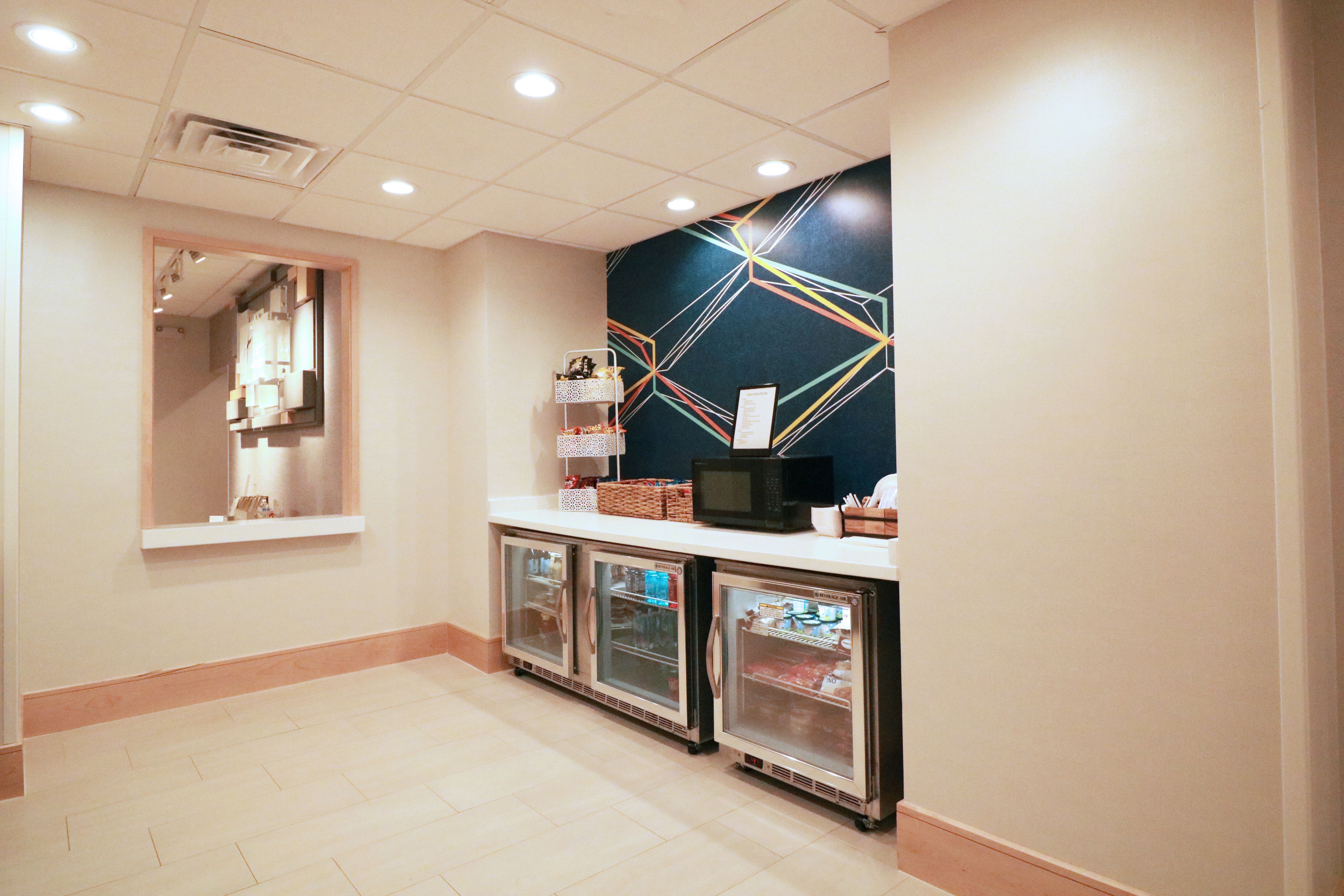 A hotel reception area with a counter, a microwave, and a refrigerator.
