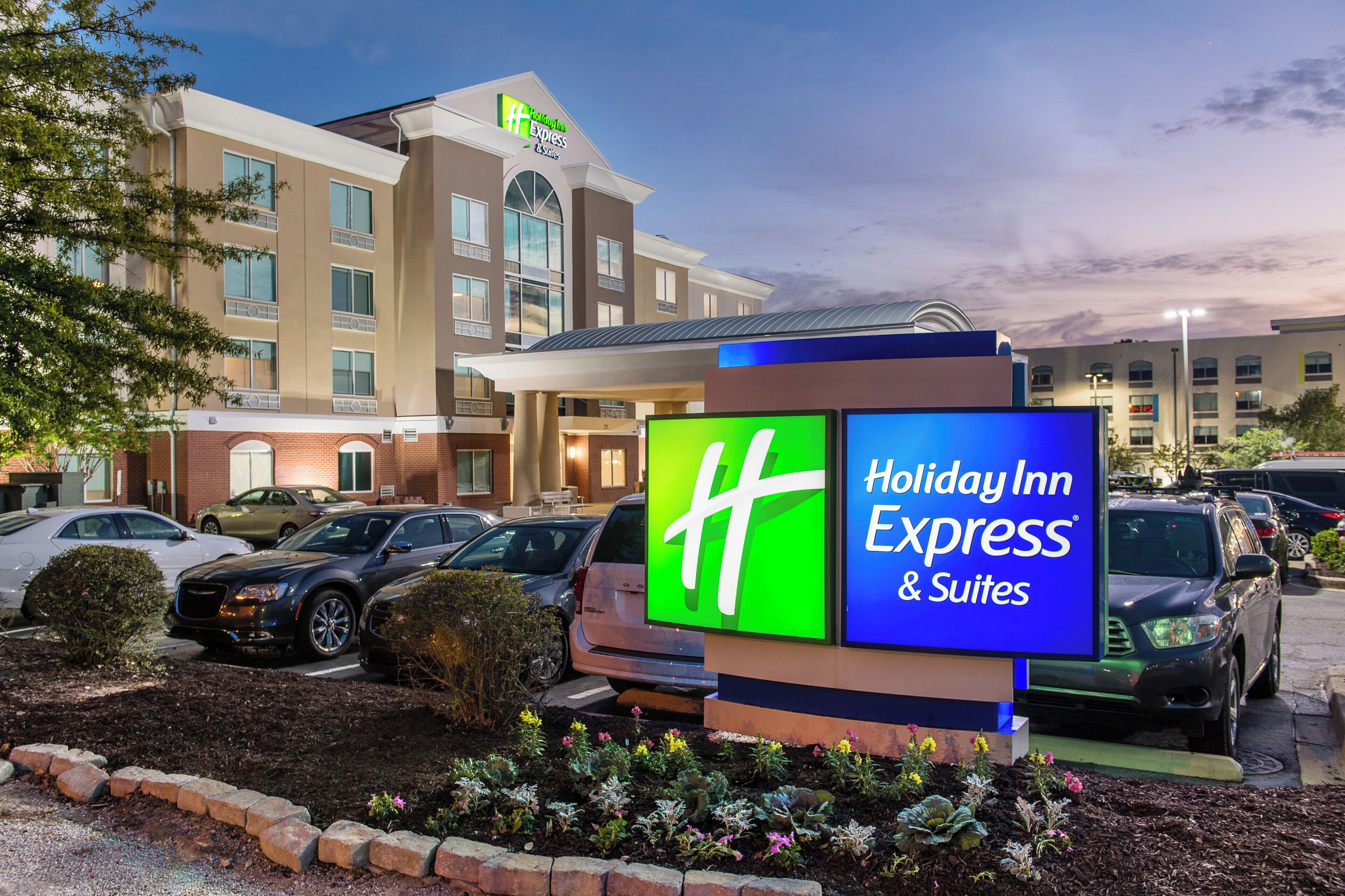 A Holiday Inn Express & Suites hotel with a parking lot and a signboard.