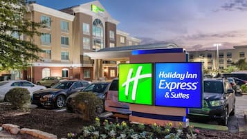 Un hotel Holiday Inn Express & Suites con estacionamiento y un cartel.