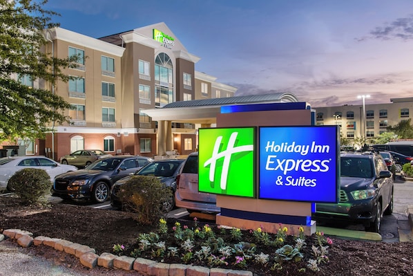 A Holiday Inn Express & Suites hotel with a parking lot and a signboard.