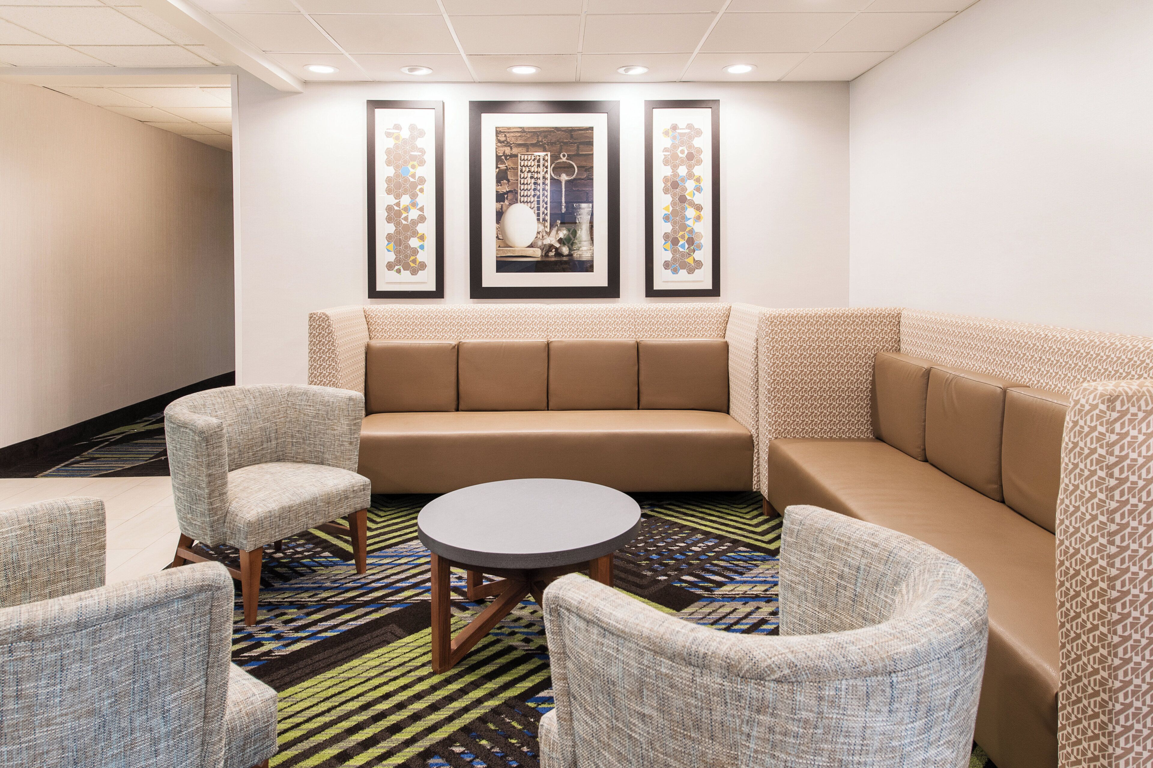 Een hotel lobby met een bank, fauteuils en een salontafel.