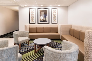 A hotel lounge with a sofa, armchairs, and a coffee table.