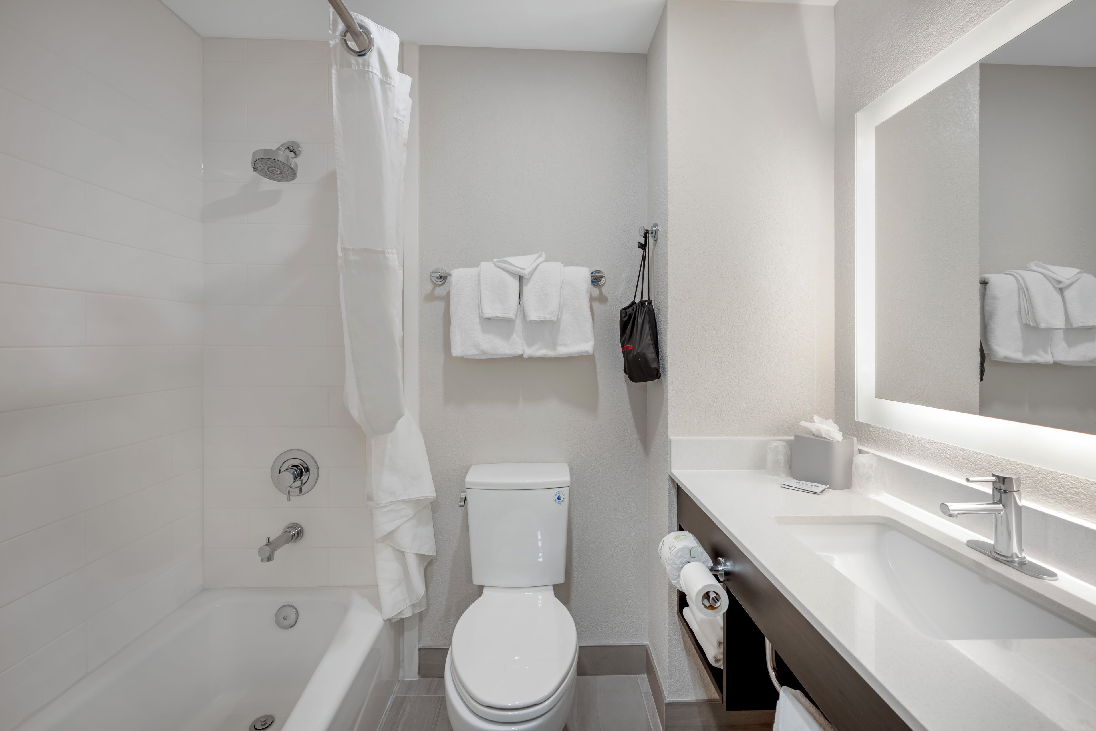 A modern bathroom with a bathtub, toilet, and sink.