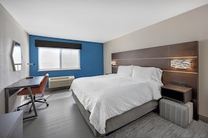 A modern hotel room with a large bed, a desk, a chair, a radiator, and a window. - Holiday Inn Express - Balloon Fiesta Park by IHG (Albuquerque)