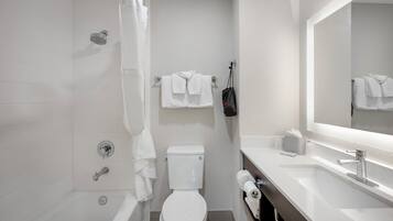 A modern bathroom with a bathtub, toilet, and sink.