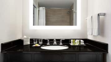 A modern bathroom with a black vanity, a white sink, and a large mirror.