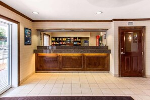 A reception area with a counter, a Coca-Cola refrigerator, and a closed door. - Studio 6 Extended Stay - Myrtle Beach, SC (Myrtle Beach)
