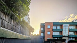 A rectangular swimming pool with a tiled edge, surrounded by a low fence and a paved walkway. - APX Parramatta (Rosehill)