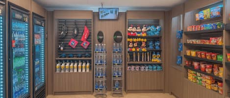 A store with vending machines, shelves of hats, and canned goods.