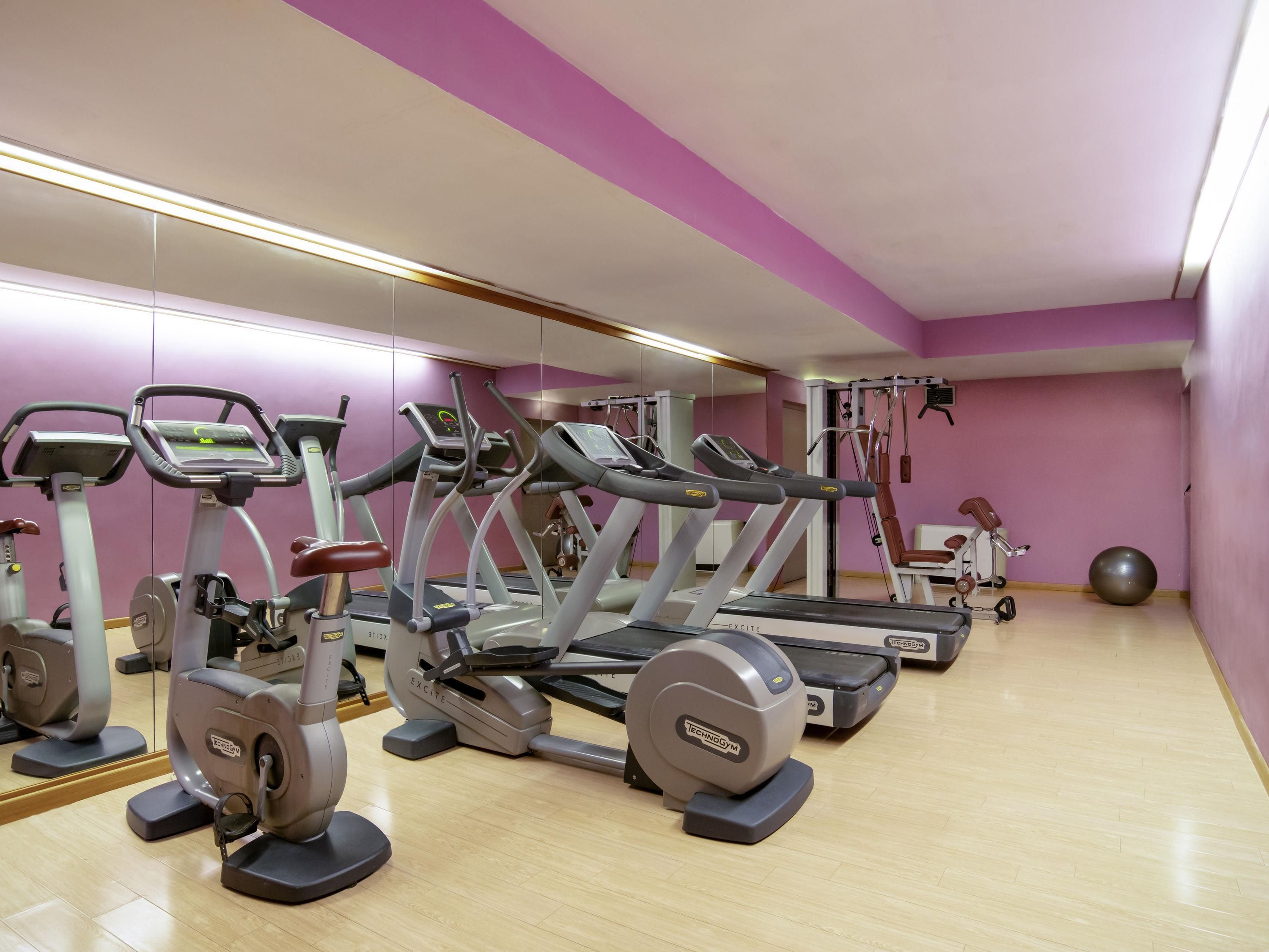 A gym with treadmills, ellipticals, and a rowing machine.