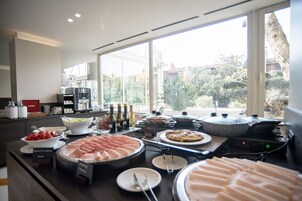 A breakfast buffet with various food items and a coffee station.