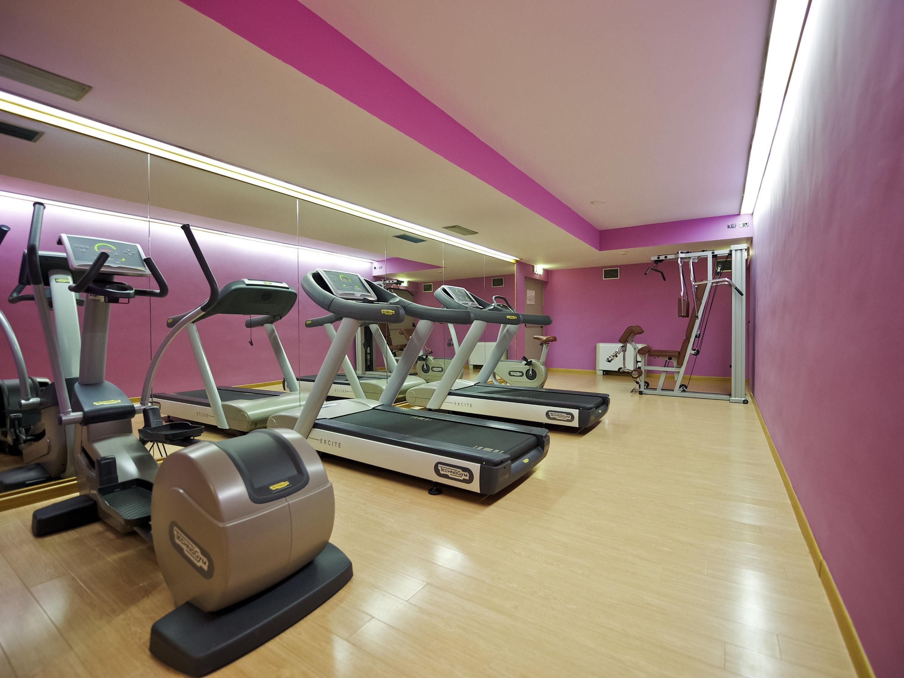 A gym with treadmills, ellipticals, and a rowing machine.