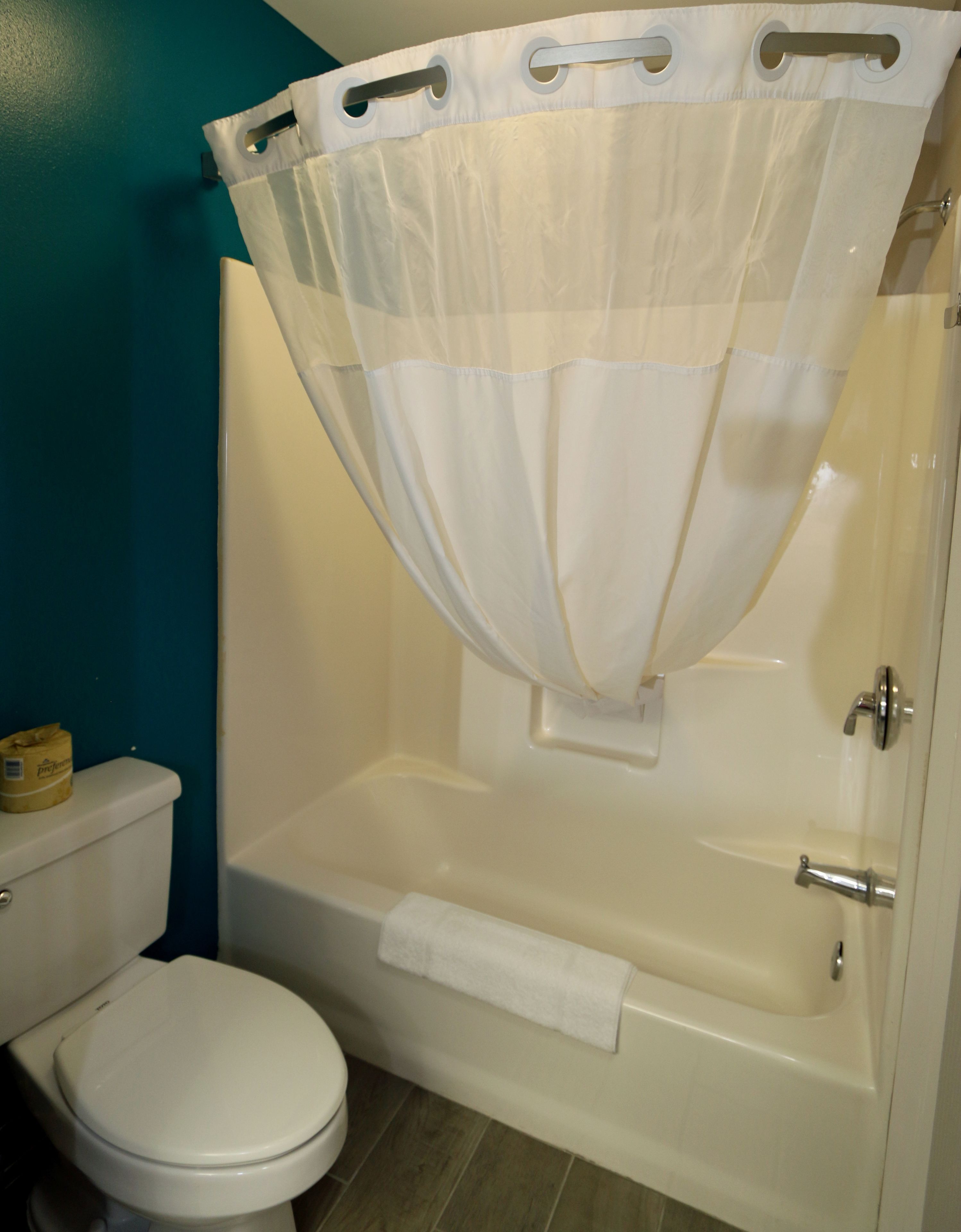 Ein Badezimmer mit Badewanne, Toilette und Duschvorhang.