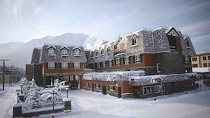 Un hôtel dont l’extérieur est recouvert de neige, qui compte plusieurs étages et qui est situé dans un cadre montagneux.
