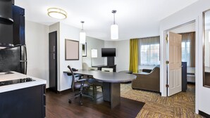 Una habitación de hotel moderna con área de cocina, una mesa de comedor y un sofá.