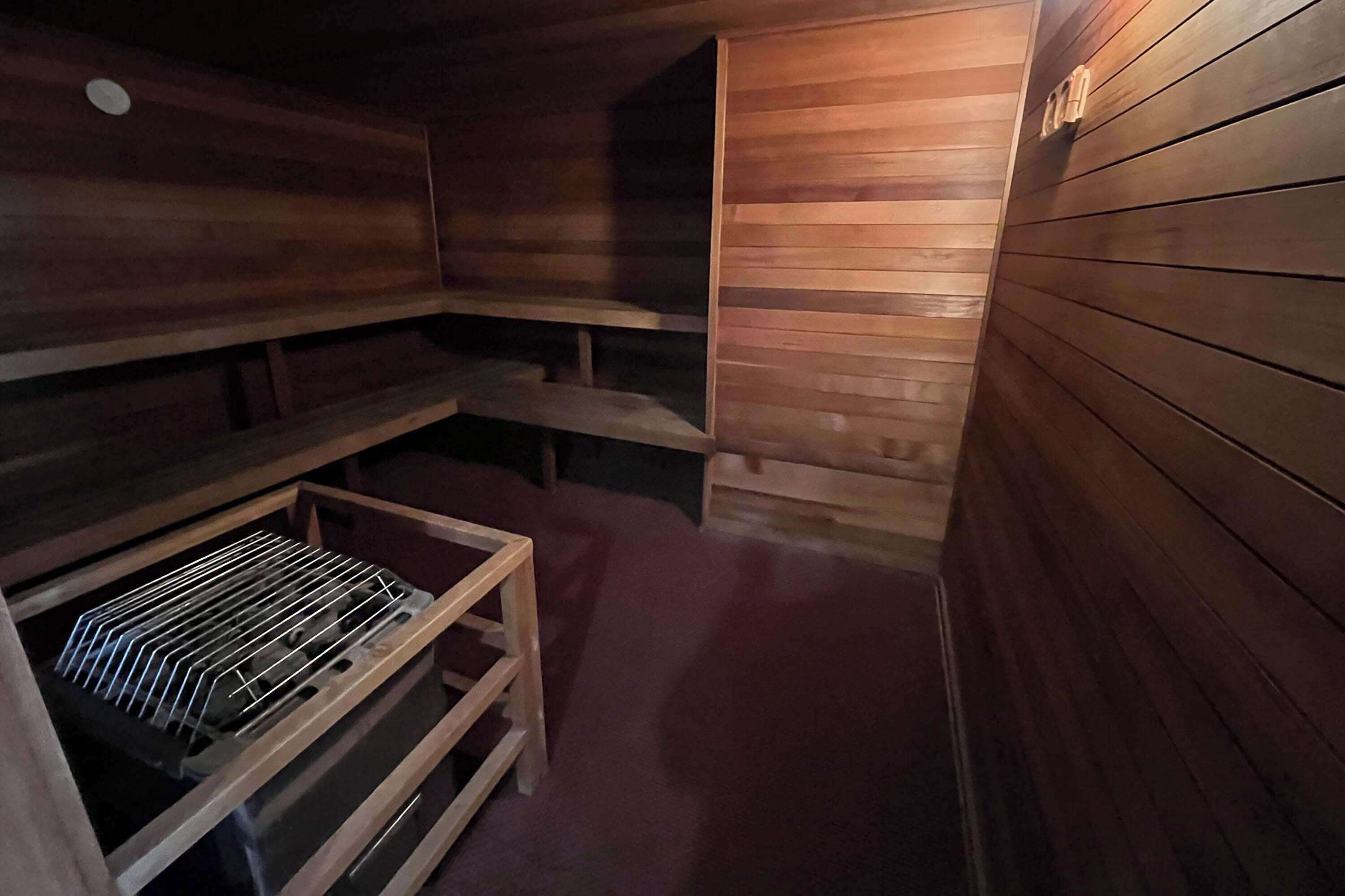 Un sauna avec des murs et des bancs en bois.