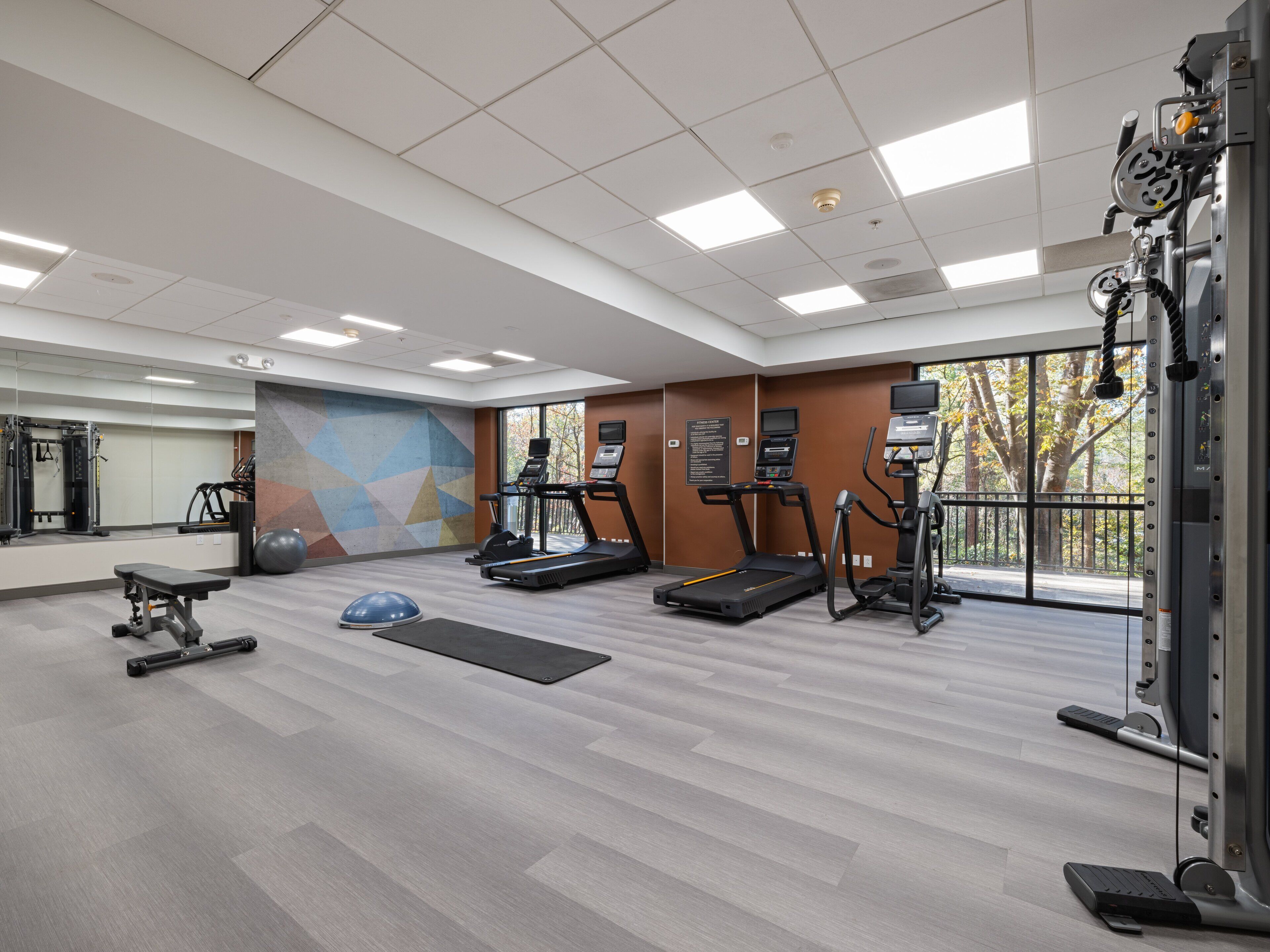 A gym with treadmills, elliptical machines, and weight equipment.